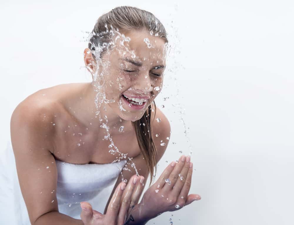 Lady splashing water on her skin