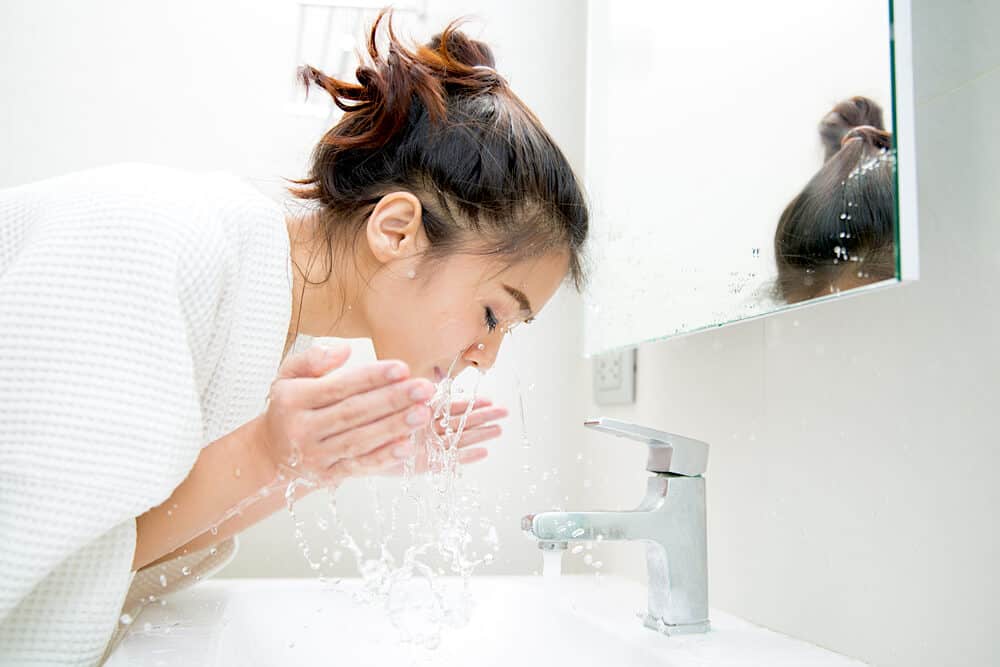 Lady splashing water on face